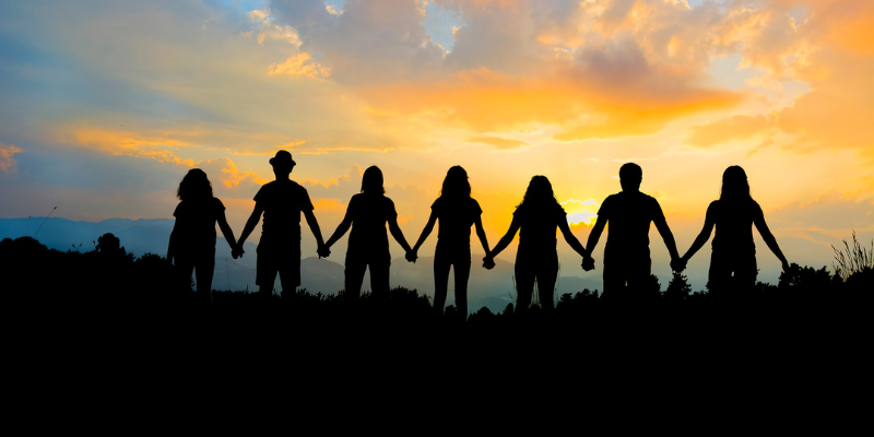 The Silhouettes of 7 People Hold Hands, Connected the Way Backlinks Show How Your Site is Connected to the Larger Community..