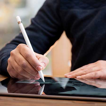 Close up image of a man using a stylus on a tablet